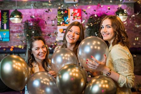 young female friends holding silver balloons enjoying party wp